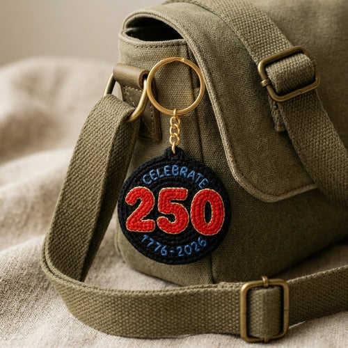 WoolyArtis 250th USA anniversary keychain featuring red, white, and blue crochet-style design with patriotic 1776-2026 motif.