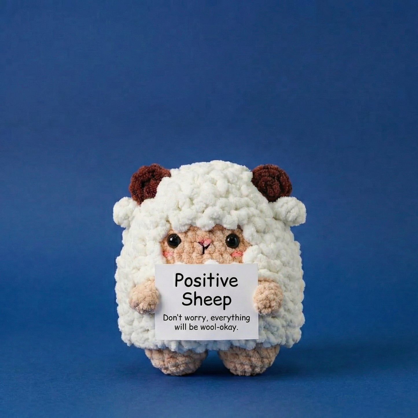 Plush toy sheep holding a sign with text on a blue background