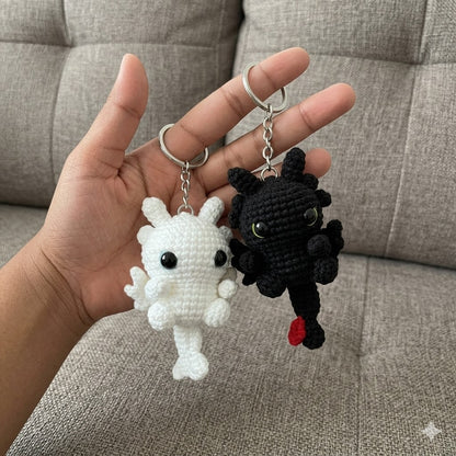 Handmade WoolyArtis crochet dragon couple keychains in black and white, featuring fantasy-style amigurumi dragons for bags or accessories.